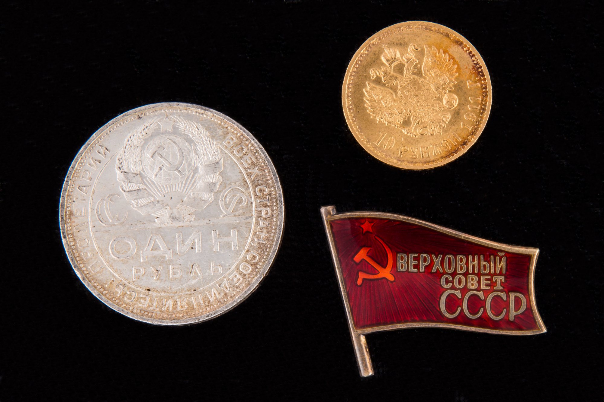 Серебряный рубль 1924 года, золотые 10 рублей 1911 года и знак «Верховный Совет СССР» на чёрном бархате